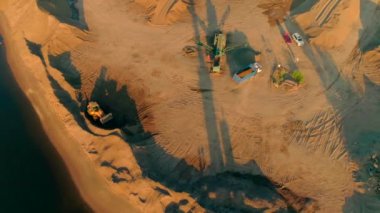 Kuş bakışı görüş. Sahne. Boş bir çöl arazisindeki büyük kamyonlar inşaat işi üretiyor..