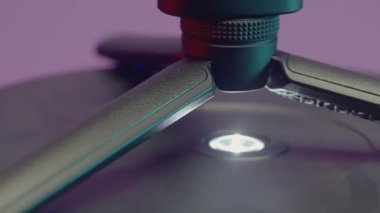 Dengeleyicinin bir parçası. Aksiyon. Dengeleyici eksen boyunca dönüyor. Mor arka planda, çekim için dengeleyiciyi çıkarıyorlar.