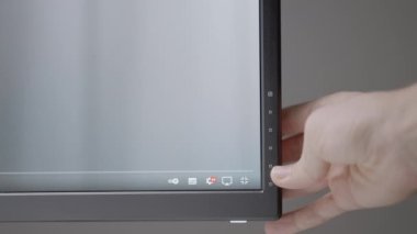 El monitörü çalışacak şekilde ayarlar. Aksiyon. Siyah bir monitör bir adamın elini ayarlar. Ekranın altındaki ayarlara hafif bir el basar