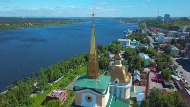 Letní slunná krajina z drone.Clip.Krásná velká katedrála se nachází ve městě vedle řeky a vedle různých obytných budov na pozadí krásné vzorované oblohy. — Stock video