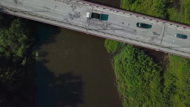 Ein langer Weg mit Autos. Eine große Brücke über den Fluss und nur eine Straße mit Autoverkehr in der Stadt. — Stockvideo
