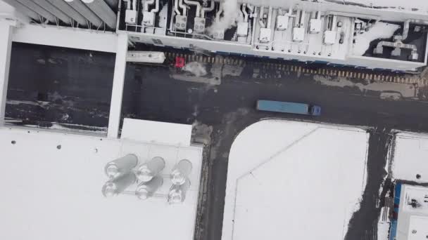 Winter view from a helicopter.Creative. A large factory in which a blue huge truck is moving from the factory territory. — Stock Video