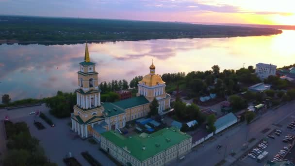 Summer sunny landscape from a drone.Clip.A beautiful large cathedral located in the city next to the river and next to various residential buildings on the background of a beautiful pattern sky. — стоковое видео