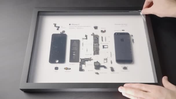 UNITED STATES OF AMERICA, WASHINGTON - MARCH 21, 2022: A man removes a film from the glass under which a disassembled iPhone. ACTION. In the frame under the glass are the details of the iPhone. All — Stock Video