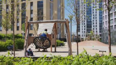 Bitkilerle dolu modern oyun parkı. Stok görüntüleri. Çocuklar modern oyun sahasında oynarlar. Yazın manzaralı ve oyun parklı bir yerleşim yeri.