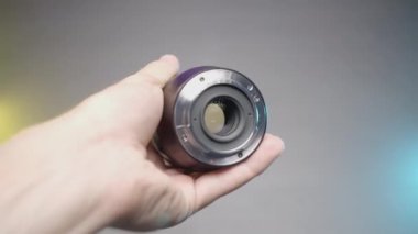 FRANCE, PARIS - 21 Mart 2022: geniş açı mercek. Aksiyon. Mor arka planda yeni bir lens gösteriliyor. SLR kamera için büyük yakınlaştırma lensi