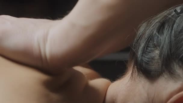 Jonge vrouw met massage in spa salon. Actie. close-up van vrouw ontspannen tijdens rug, nek, en hoofd massage liggend op massagetafel. — Stockvideo