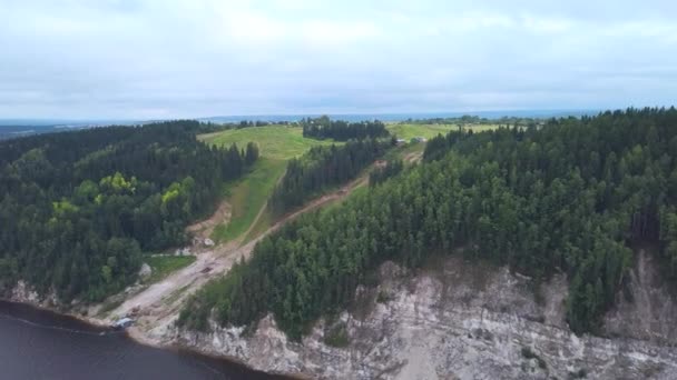 Hermosa montaña verde.Clip.La vista desde el dron. Una gran colina con grandes abetos alrededor y un camino que se encuentra en el río. — Vídeos de Stock