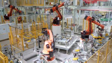 Rusya, Moskova - 7 Mayıs 2022: Robot ve işçilerle otomatikleştirilmiş fabrika. Sahne. Birçok robot makine modern fabrikada araba parçaları üretir. İşçilerin olduğu fabrikada modern robotik ekipman