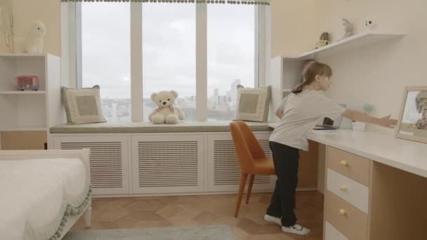 Holčička s culíkem v bytě. Tvůrčí. Malé dítě ve svém pokoji s plyšovými hračkami, které si sedne k počítači a rozsvítí světlo. — Stock video