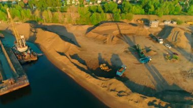 Güneşli bir yaz gününde, nehrin yakınındaki kum ve çakıl madenlerinde insansız hava aracı uçuşu. Sahne. Ağır sanayi ve makine kavramı.