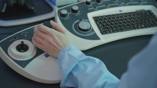 Visa över axeln på kvinnliga läkare med hjälp av kontrollpanelen i en medicinsk maskin för sonografi. Lagerbilder. Ultraljudsundersökning, begreppet hälsa och medicin. — Stockvideo