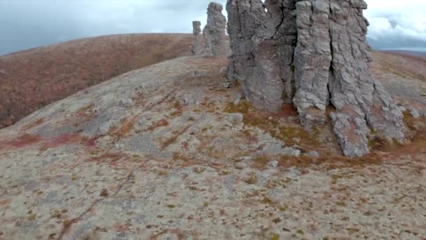 Vista aérea de un pico de una montaña con formaciones rocosas de piedra. Clip. Hermosa cima de la colina con pilares de piedra en otoño temporada. — Vídeos de Stock