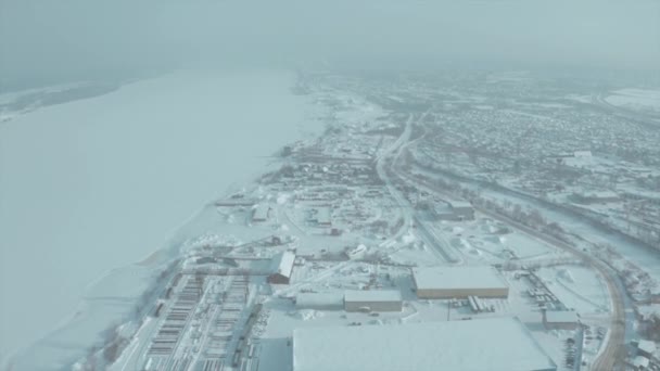 Légi kilátás a város lakóépületek és egy folyó télen, városi téli táj. Csípés. Hó borította város a reggeli ködben. — Stock videók