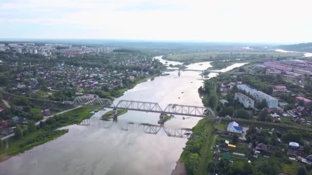 Russie.La vue depuis le drone.Clip. Une grande ville d'une hauteur où vous pouvez voir des maisons d'été et des arbres verts autour et un grand pont sur la rivière qui se propage et vous pouvez voir le brouillard blanc sur la — Video