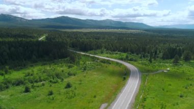 Ormanlı güzel otobanın manzarası ve dağların arka planında yeşillik. Sahne. Yazın yeşil orman ve dağların arka planındaki manzara