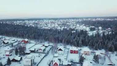Ormanda kışın renkli evleri olan güzel şehir manzarası. Şarjör. Kışın ormanlık alanda kulübeleri olan bir kasaba. Ormanın ortasında sıcak bir kış kasabası
