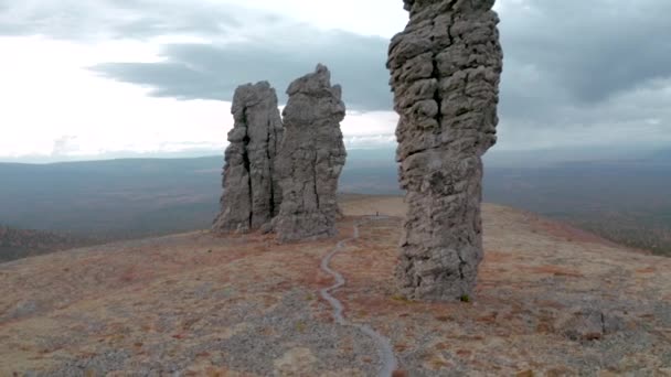 Κάτοψη των πέτρινων πυλώνων στο βουνό. Κλιπ. Φυσικοί πέτρινοι πυλώνες στο βουνό σε συννεφιασμένη ημέρα. Τοπίο με μυστηριώδεις πέτρινες κολώνες στο βουνό — Αρχείο Βίντεο