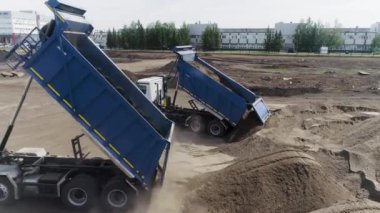 Kazıcının hava görüntüsü bir çöp kamyonuna kil toprağı topluyor. Sahne. İnşaat alanında faaliyet, ağır sanayi konsepti.