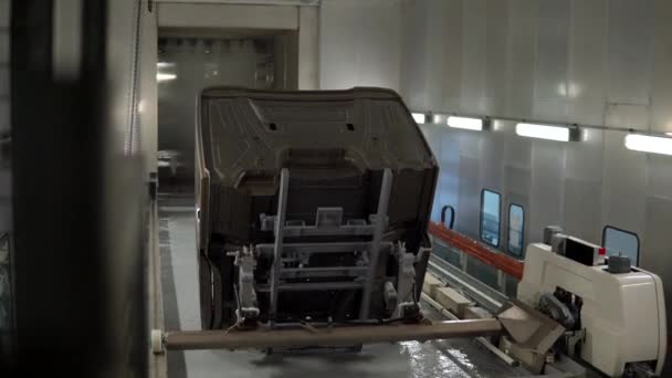 Zobacz wnętrze warsztatu w fabryce samochodów ciężarowych. Scena. Automatyczne umieszczanie metalowego nadwozia w specjalnym rozwiązaniu. — Wideo stockowe