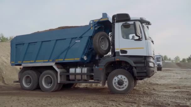 Rusia, Moscú - 7 de mayo de 2022: Camiones en obra o cantera. Escena. Los camiones volquete con tierra salen del sitio de construcción. Camiones volquete sacan tierra del sitio de construcción despejado — Vídeo de stock