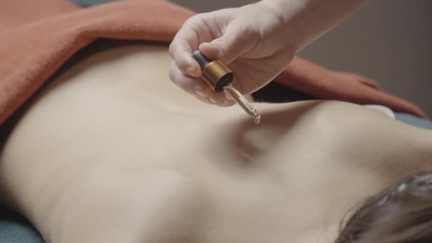 Спа-процедури. Дія. Застосування олії до жіночого організму, яке потім натирається і масажується. — стокове відео