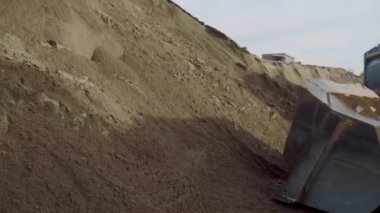 Aşağıdaki manzaraya bak. Büyük traktörler boş bir dağda, inşaat sürecinde..