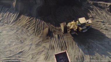 Kazıcı plajı temizliyor. Sahne. Plaj alanının en üst manzarası. Kazıcı ve çöp kamyonları yazın kıyı şeridini temizler. Sahilde inşaat işi.