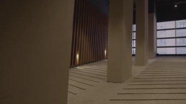 Parlak bir koridor. Ofis binasında geniş sütunlar ve pencereler var..