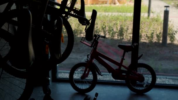 Parcheggio per biciclette all'interno dell'edificio con finestre panoramiche. Filmati delle scorte. Biciclette parcheggiate per bambini e adulti al chiuso. — Video Stock