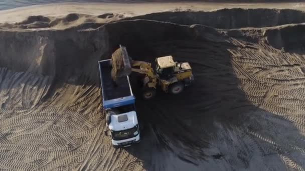 La pelle nettoie la plage. Scène. Vue de dessus de la clairière de la plage. Excavatrice et camions à benne basculante nettoient la partie côtière en été. Travaux de construction sur plage — Video