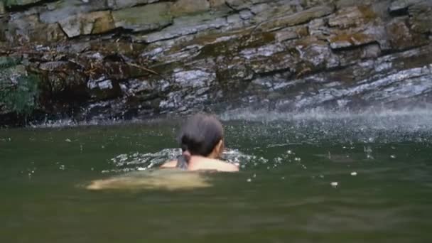 A lány sekély vízbe merül. KREATÍV. Van egy tó a kövek mellett. Egy hosszú hajú férfi fürdik egy tóban. Egy kövér lány merül egy tóban. — Stock videók