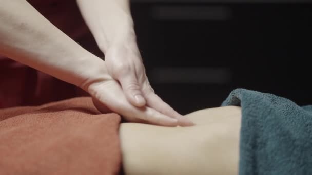 Крупним планом масажист плавно займається масажем. Дія. Ніжні згладжуючі рухи масажиста. Масажист робить розслабляючий масаж. СПА салон — стокове відео
