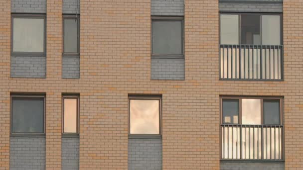 The facade of the new brick high rise apartment building with balconies. Stock footage. Brown brick house with windows. — Stock Video