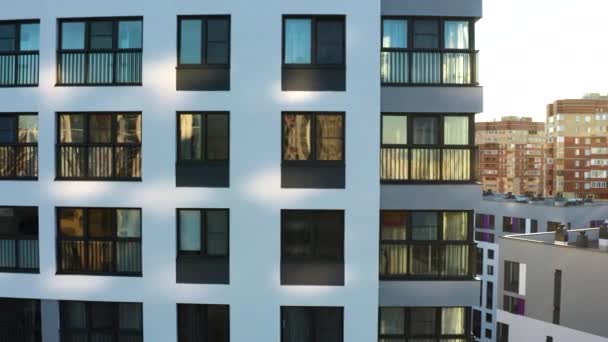 Темные окна белого многоэтажного здания. Запись. Вид с воздуха на жилые небоскребы в летний солнечный день. — стоковое видео