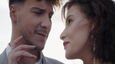 Güzel bir çiftin öpüştüğü yakın çekim. Başla. Çekici bir çift yeni evli ve nazikçe öpüşüyor. Gökyüzünde öpüşen güzel aşıklar