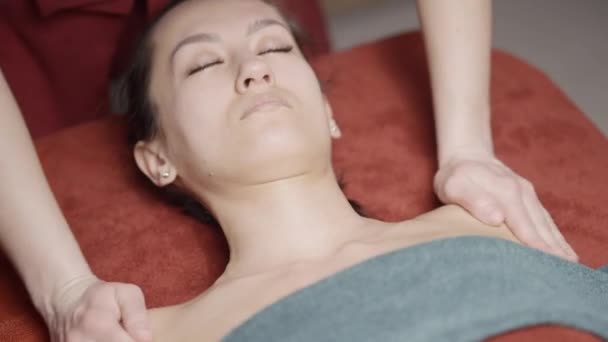 Massagem de parte dianteira de corpo. Acção. Massagem rejuvenescedora e relaxante no spa. Massagem profissional de clavícula e cara. Salão de Spa — Vídeo de Stock