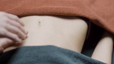 Rahat ol. Hareket. Yağ vücuda havlularla damlıyor ve yüksek kaliteli bir masaj için ovuluyor.