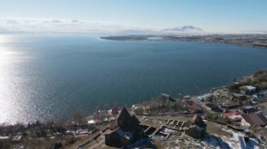 Kıyı manzaralı güzel bir manzara. Sahilde yerleşim yerleri olan deniz manzaralı parlak bir manzara ve mavi gökyüzünü görebilirsiniz..