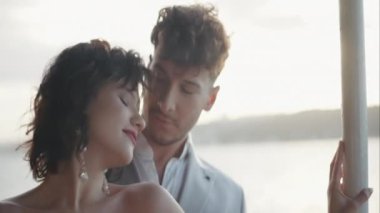 Yakışıklı bir adam ve güzel bir kadın nehir kenarında buluşup kucaklaşıyorlar ve gülüyorlar. Başla. Kıvırcık saçlı bir kadın ve açık havada sevgi dolu bir erkek.