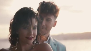 Güneşli arka planda güzel, şık bir çift. Başla. Çekici yeni evliler güneşin bulanık arka planında dururlar. Şık ve zarif bir çift yeni evli.. 