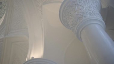 Caminin içinde dekoratif tavan ve duvarlar var. Sahne. Mermer kolonları olan güzel beyaz cami.