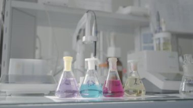 Laboratuvarda bilimsel ya da kimyasal deneyler için cam ekipman. Başla. Laboratuvarda şişeler sıvı maddeyle dolu.