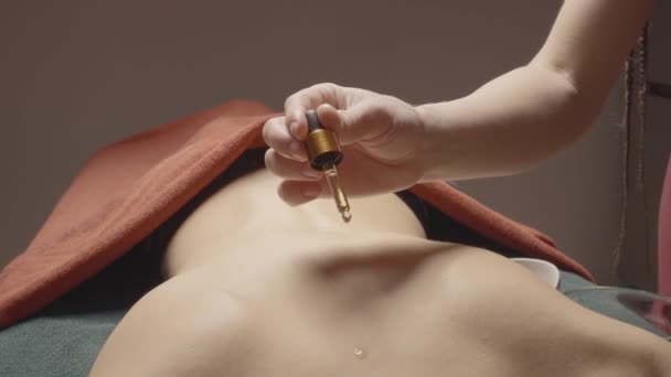油滴在背上的特写 按摩师在按摩前把油倒在背上 用香精油按摩放松身体 — 图库视频影像