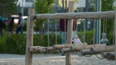 Geniş bir oyun alanı. Stok görüntüleri. Çocuklar için ahşap parmaklıklar, koşan çocuklar ve aileleri arkalarından görülebiliyor. Yüksek kalite 4k görüntü