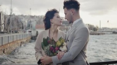 İki mankenle güzel bir düğün fotoğrafı çekimi. Aksiyon. Uzun takım elbiseli ve bir buket çiçekli genç bir çift setin üzerinde birbiriyle flört ediyor. Yüksek