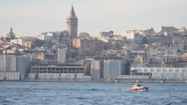 Eski şehrin arka planında kulesi olan yatı olan güzel bir manzara. Başla. Eski kulesi olan deniz kenti kıyıları. Güneşli bir günde İstanbul açıklarında tekne gezisi. 