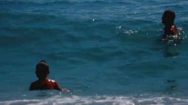 Çocuk Yaratıcı ile parlak deniz manzarası. Güçlü dalgalarda yüzen küçük çocuklar. Yüksek kaliteli FullHD görüntüler
