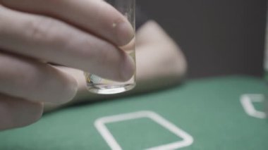 Poker oynarken tekila içen gözlüklü adama yaklaş. Başla. Yeşil poker masasında dinlenen adam