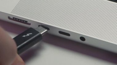 Bilgisayara yerleştirilmiş şarj kablosunun yakın plan görüntüsü. Başla. Telefonunu dizüstü bilgisayarla şarj ediyorsun. Telefon şarj kablosu dizüstü bilgisayara bağlandı. 